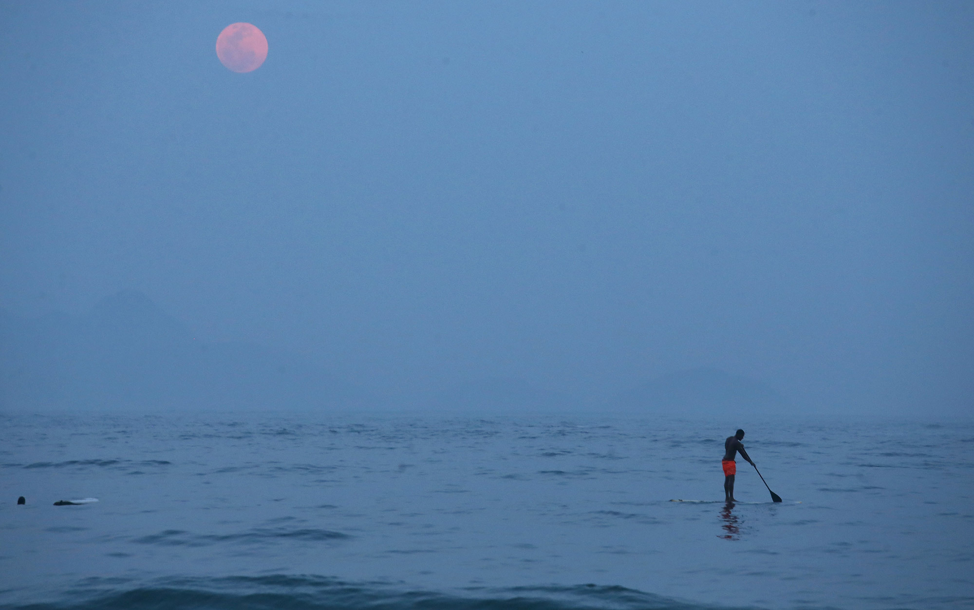 fisher and moon on lake, from Aeon Magazine